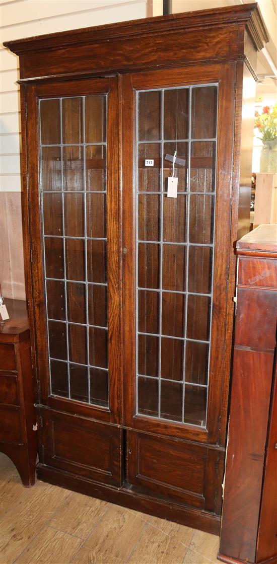 A 1920s oak leaded light bookcase W.96cm